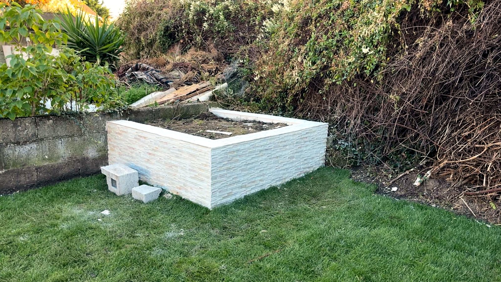 New white-clad raised bed finished on a fresh green lawn