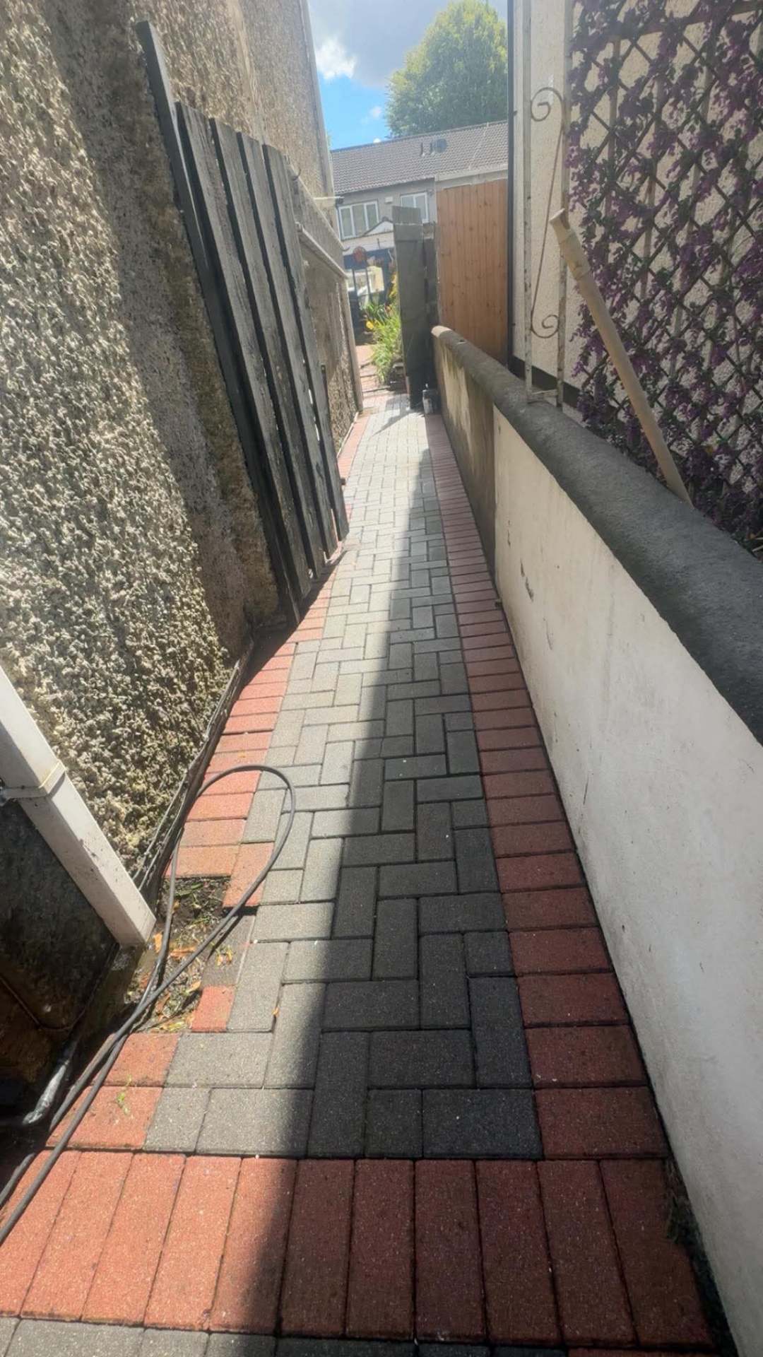 Same side passage cleared and power washed back to clean red and grey paving